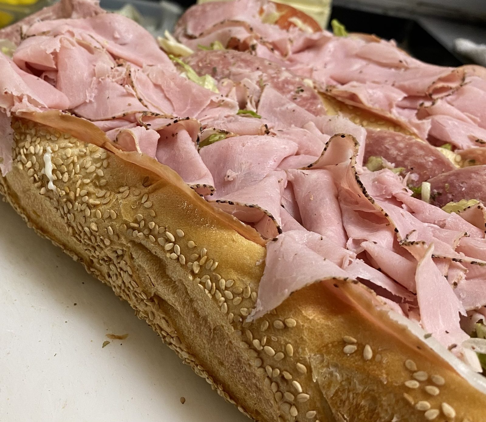 Loaded Italian hoagie with ham, salami, capicola, and provolone on a sesame seed roll